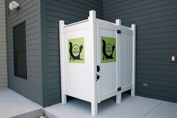 A white gate with two signs on it that say pet waste.